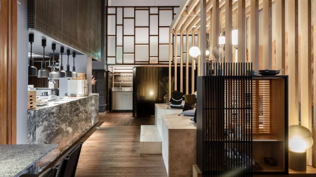 Vrå interiör japansk sittning med utsikt över kök i sten och trä